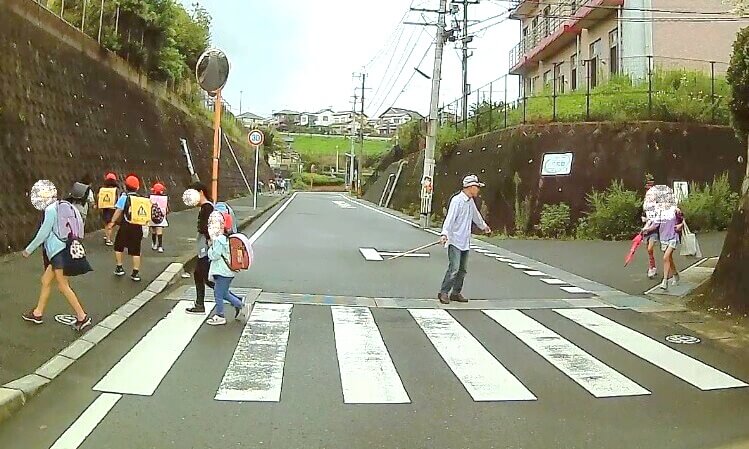 元気に登校する子ども達、横断歩道を渡っている写真