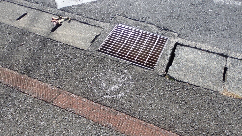 横断歩道手間の消えかけている「とまれ表示」の写真