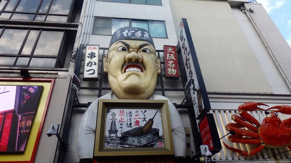 串かつだるま店主?をオブジェにした看板の写真